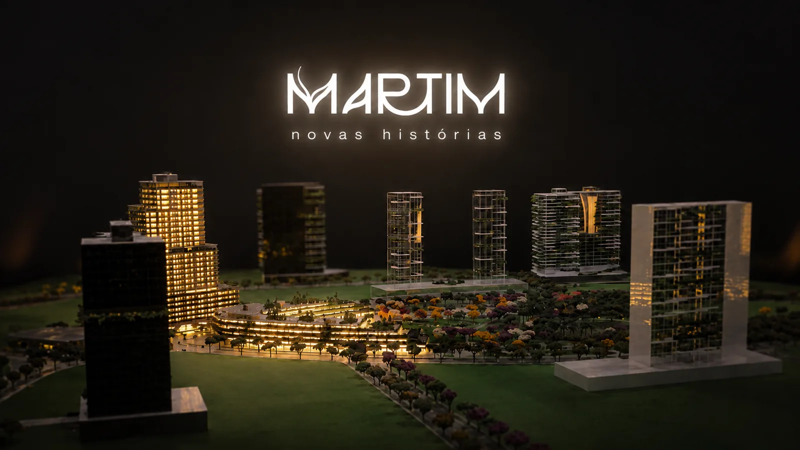 Maquete física do masterplan do Parque Una iluminada à noite, com o letreiro Martim novas histórias